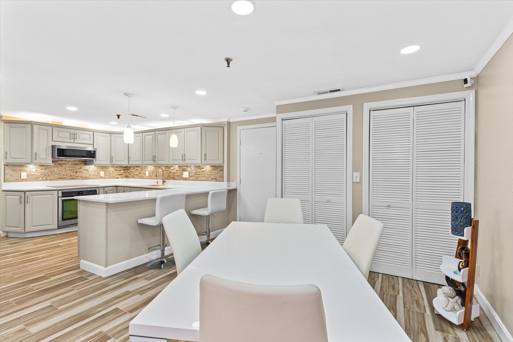 45 Christopher Drive, Unit 93 Methuen, MA 01844 - Photo 8 of 37 a large white kitchen with a white countertops a stove a dining table and chairs