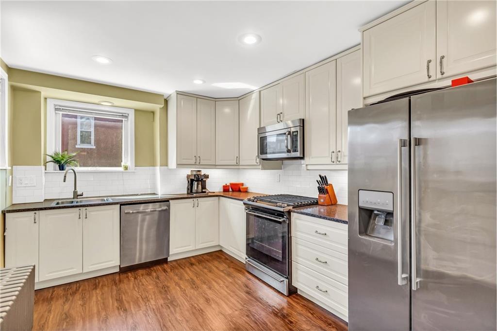 164 37th Street Pittsburgh, PA 15201 - Photo 6 of 24 a kitchen with white cabinets and stainless steel appliances