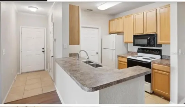a kitchen with stainless steel appliances granite countertop a sink a stove and a refrigerator