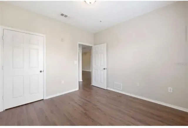 a view of an empty room with wooden floor