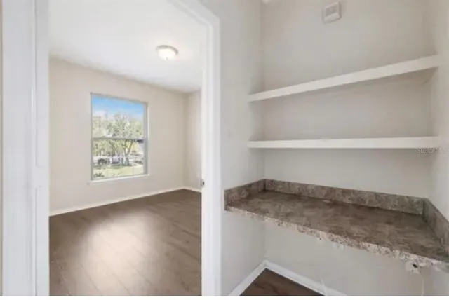a living room with hard wood floors and a window