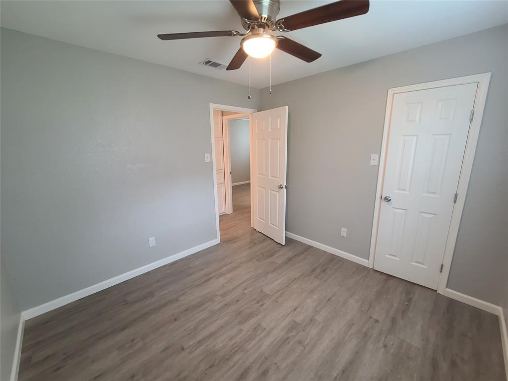 343 Spring Branch Lane Kennedale, TX 76060 - Photo 20 of 39 an empty room with wooden floor a ceiling fan and closet