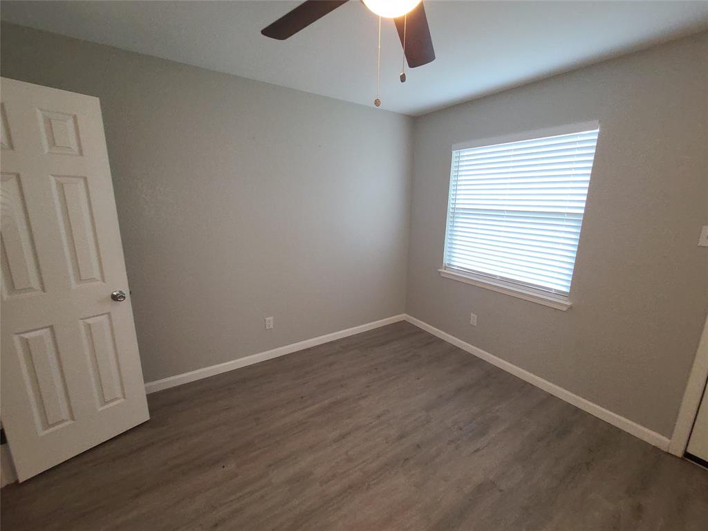 343 Spring Branch Lane Kennedale, TX 76060 - Photo 28 of 39 an empty room with wooden floor fan and window