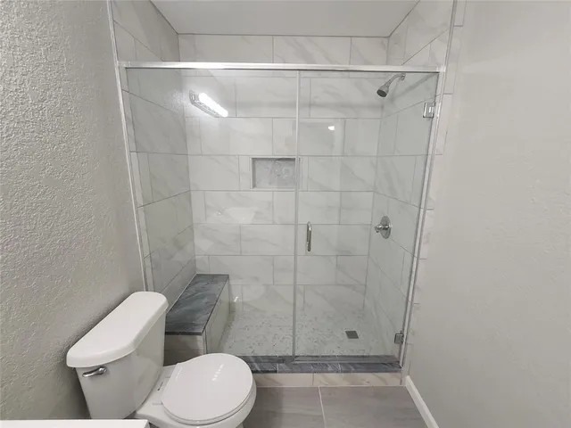 a bathroom with a toilet and a shower