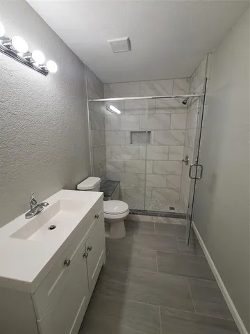 a bathroom with a double vanity sink toilet and shower