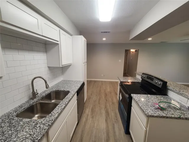 a kitchen with a sink and a stove top oven