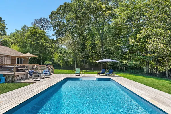 a swimming pool view with a seating space and a garden