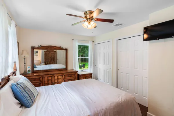 a bedroom with a bed and a flat tv screen on dresser