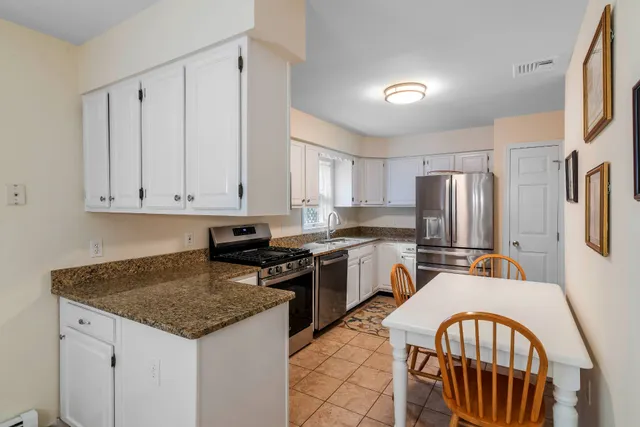 a kitchen with stainless steel appliances granite countertop a stove a sink dishwasher a refrigerator and cabinets