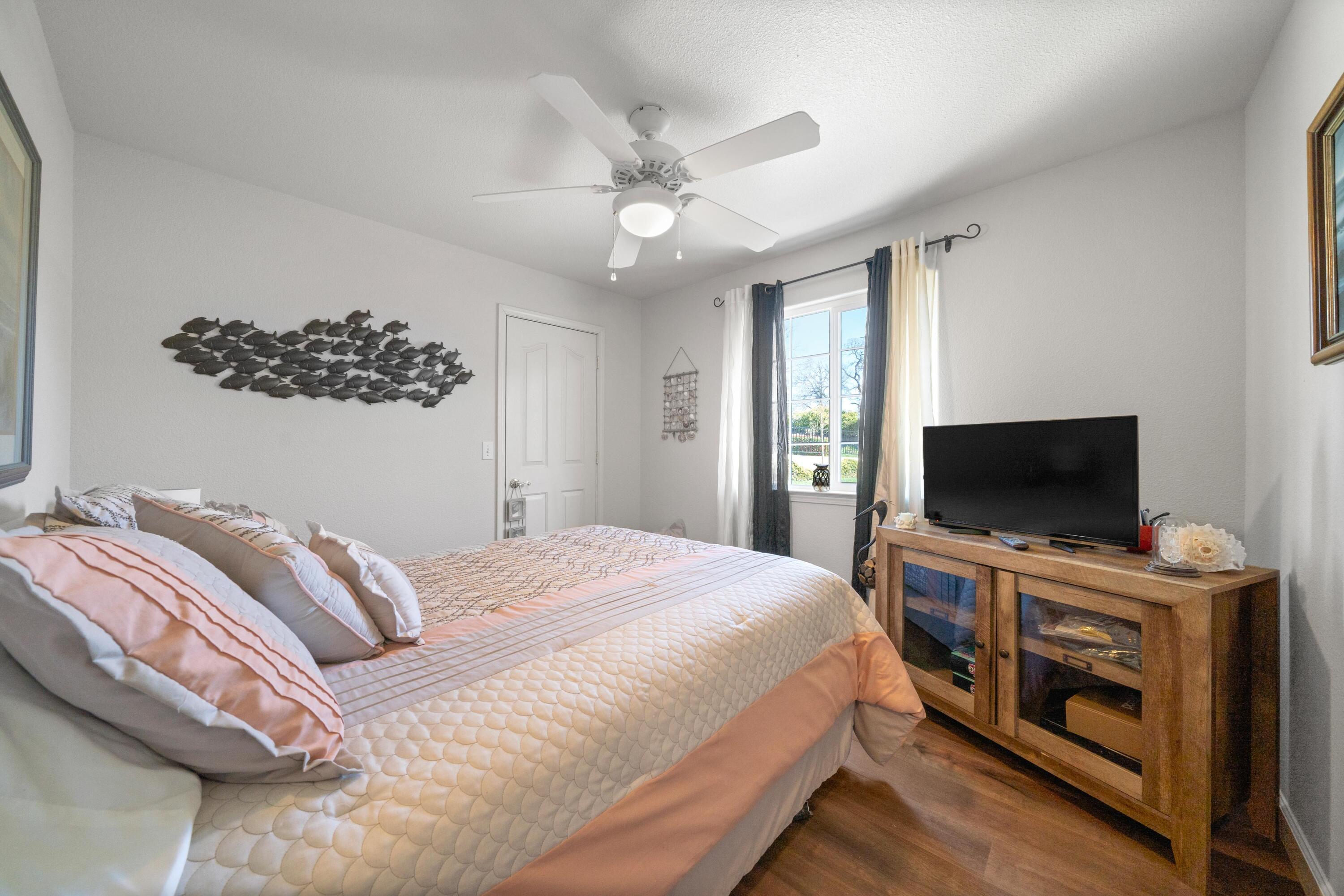 775 Stonebriar Trail Redding, CA 96003 - Photo 12 of 32 a bedroom with a bed and a flat screen tv