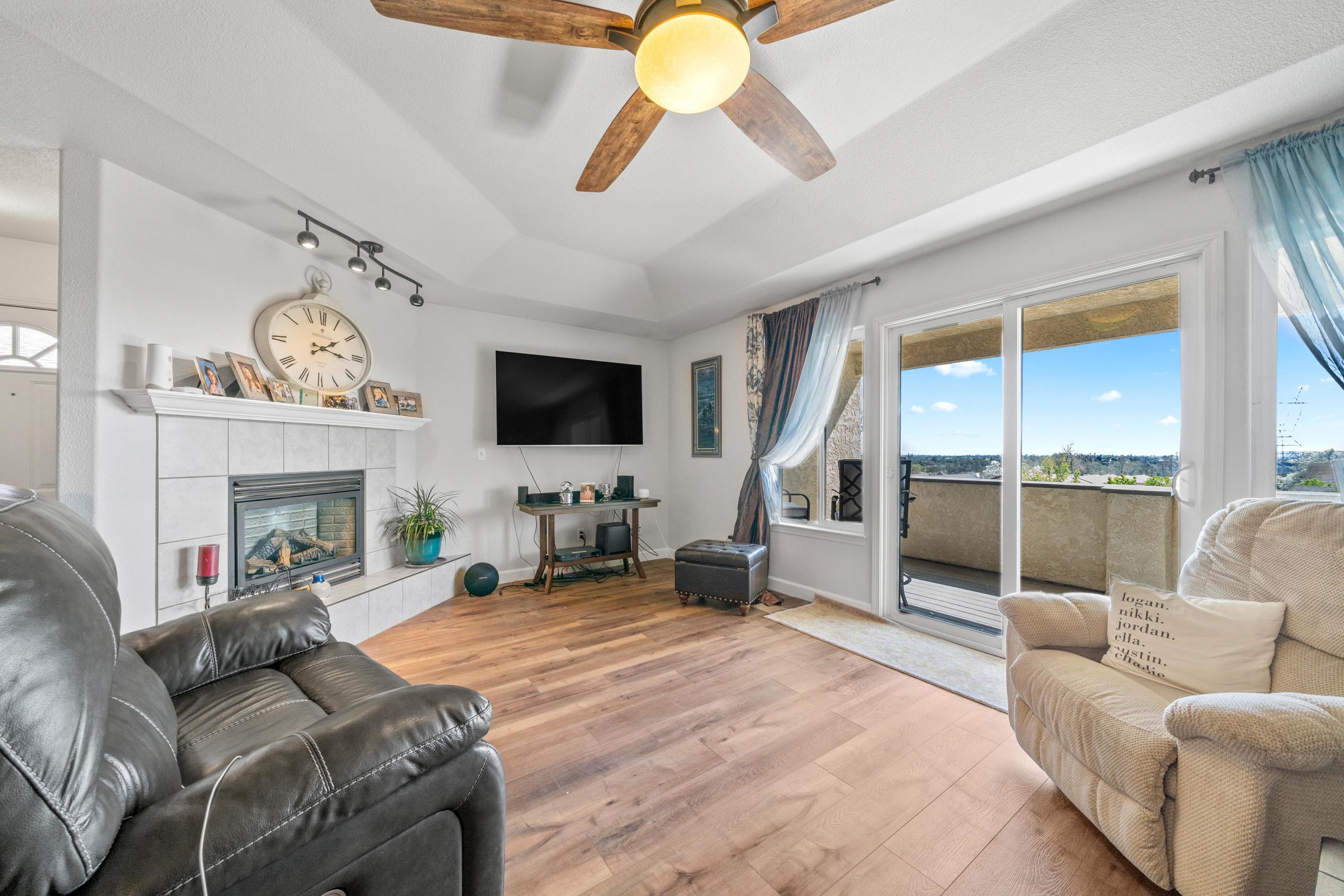 775 Stonebriar Trail Redding, CA 96003 - Photo 5 of 32 a living room with furniture a fireplace and a flat screen tv