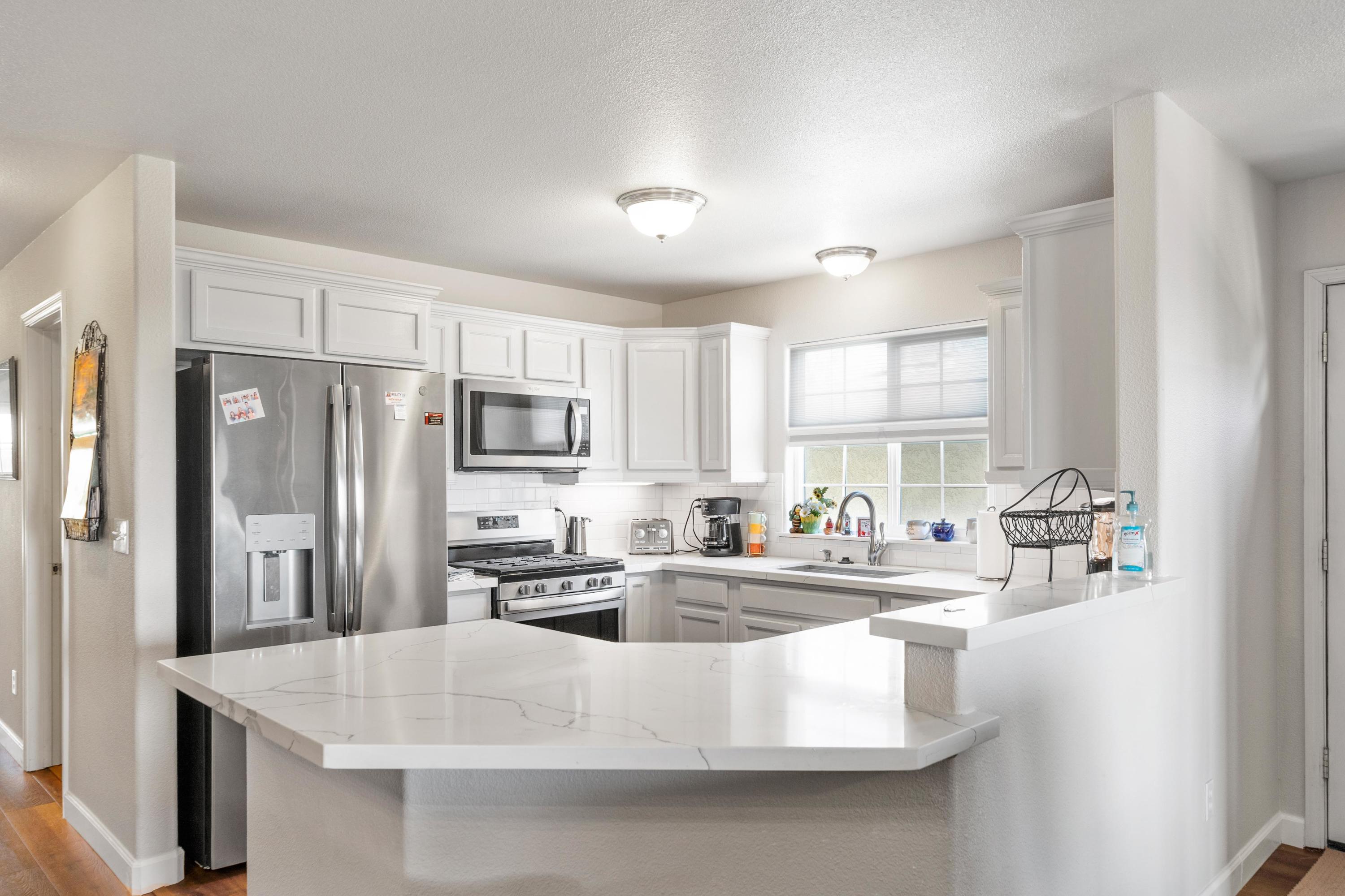 775 Stonebriar Trail Redding, CA 96003 - Photo 9 of 32 a kitchen with stainless steel appliances granite countertop a sink a stove a refrigerator a counter top space and cabinets