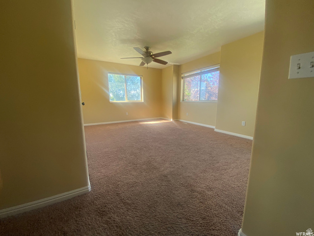 83 Canterbury Circle Logan, UT 84321 - Photo 12 of 23 Unfurnished room featuring carpet floors and a ceiling fan