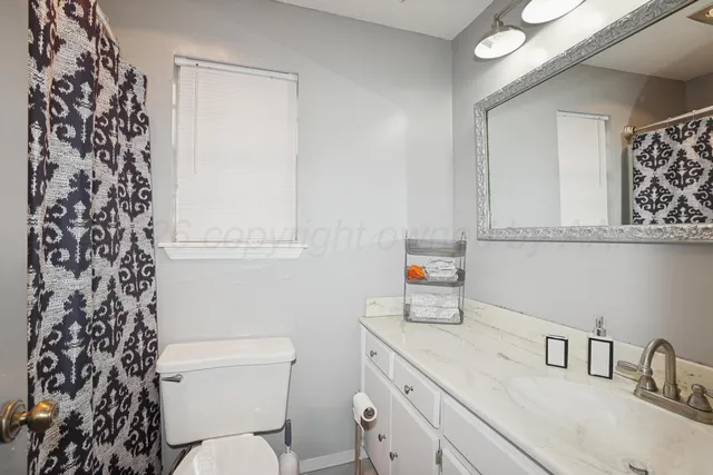 a bathroom with a sink toilet vanity and tub