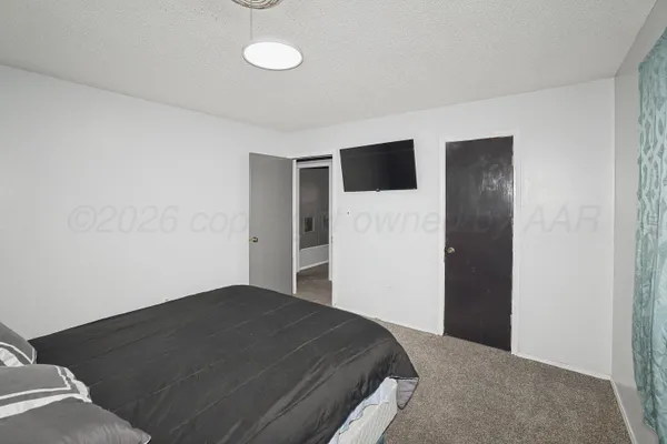 a bedroom with a bed and a flat screen tv