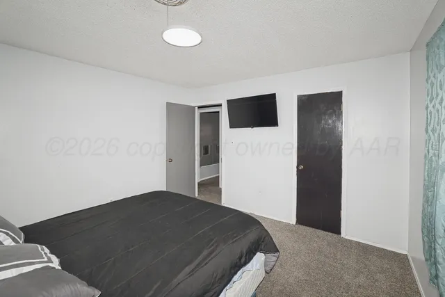 a bedroom with a bed and a flat screen tv