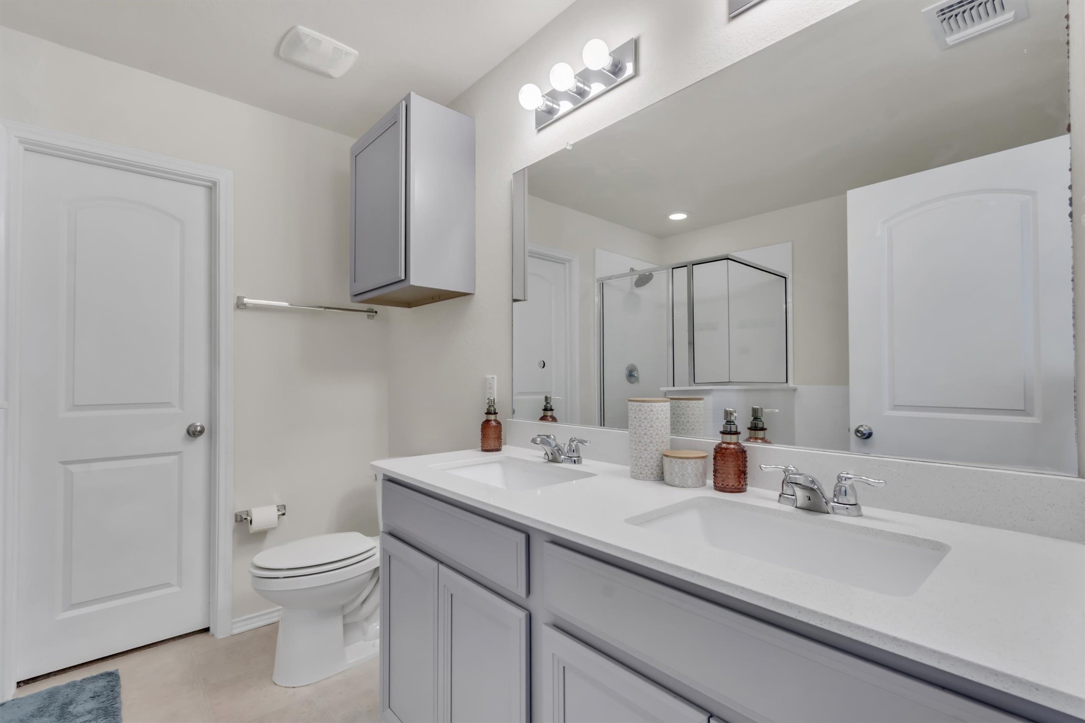 11701 Jackson Falls Way Manor, TX 78653 - Photo 17 of 40 Double vanity and large mirror create a functional and open primary bathroom space.