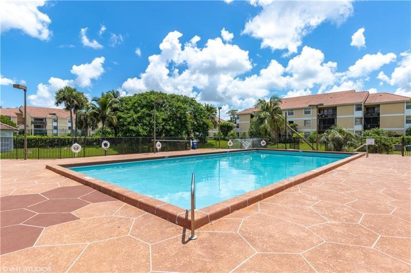 5641 Riverside Drive, Unit 202B1 Coral Springs, FL 33067 - Photo 11 of 14 a view of a swimming pool with a yard