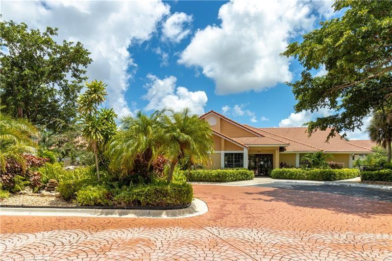 5641 Riverside Drive, Unit 202B1 Coral Springs, FL 33067 - Photo 13 of 14 a front view of a house with a garden