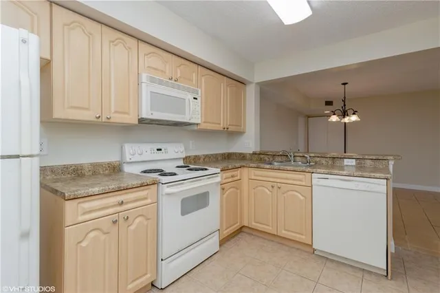 a view of a kitchen with a sink dishwasher a refrigerator and a stove