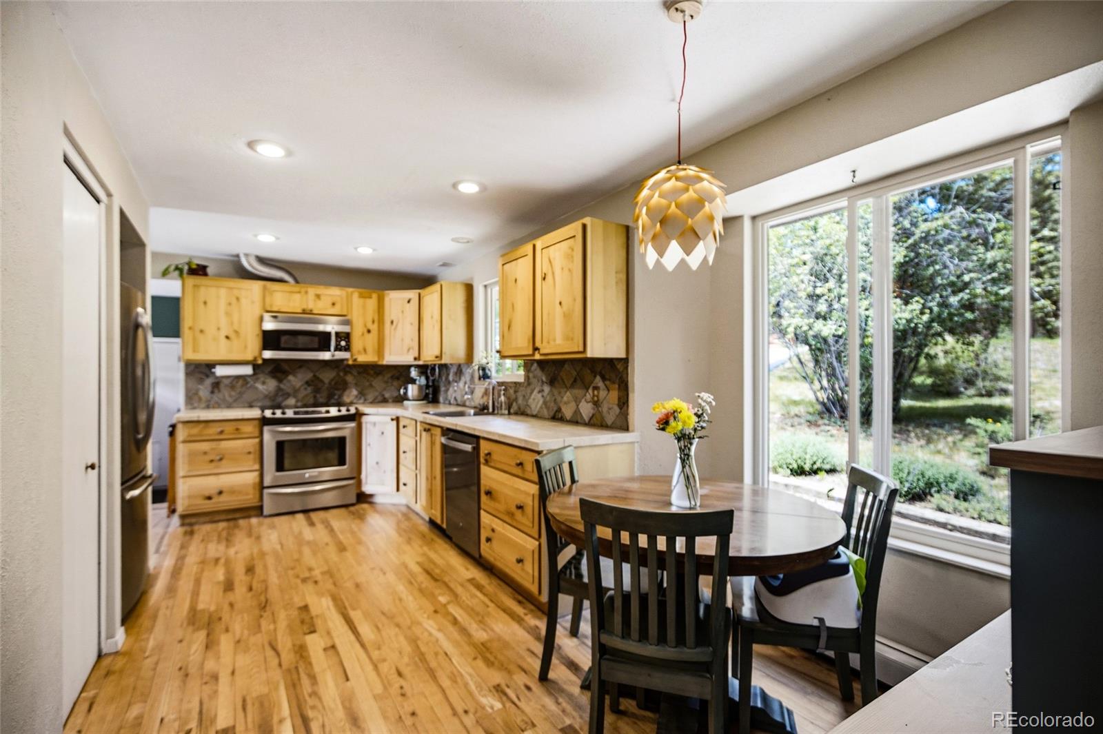 31280 Florence Road Conifer, CO 80433 - Photo 16 of 48 a kitchen with a table chairs appliances and cabinets