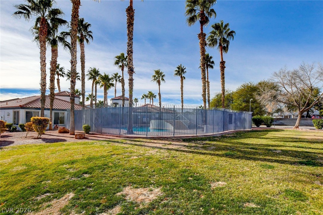 3318 North Decatur Boulevard, Unit 2072 Las Vegas, NV 89130 - Photo 37 of 50 A community pool surrounded by towering palm trees offers a refreshing oasis under the clear blue sky.