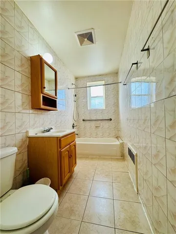 a bathroom with a toilet a sink a mirror and bathtub