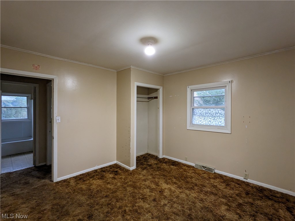 38 Frederick Street Rittman, OH 44270 - Photo 11 of 13 Unfurnished bedroom with multiple windows, a closet, and dark carpet