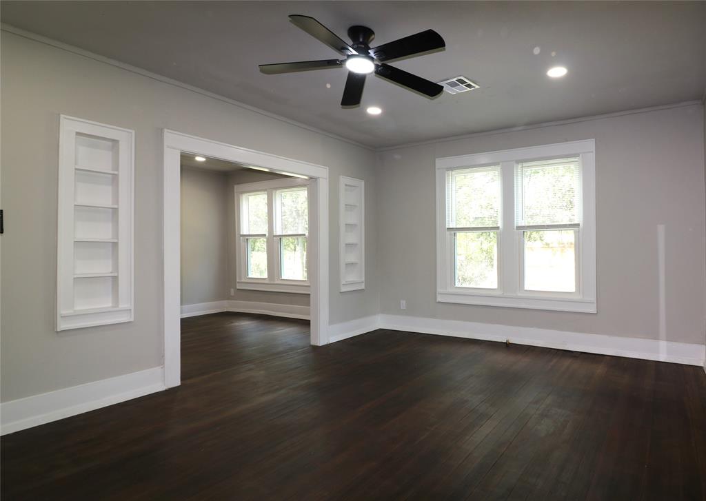 929 Vitalious Street Ranger, TX 76470 - Photo 5 of 22 Empty room with built in shelves, crown molding, dark wood-style flooring, recessed lighting, and a ceiling fan