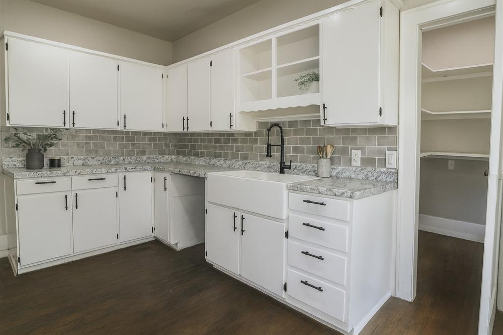 929 Vitalious Street Ranger, TX 76470 - Photo 8 of 22 Kitchen featuring open shelves, light countertops, white cabinetry, and decorative backsplash