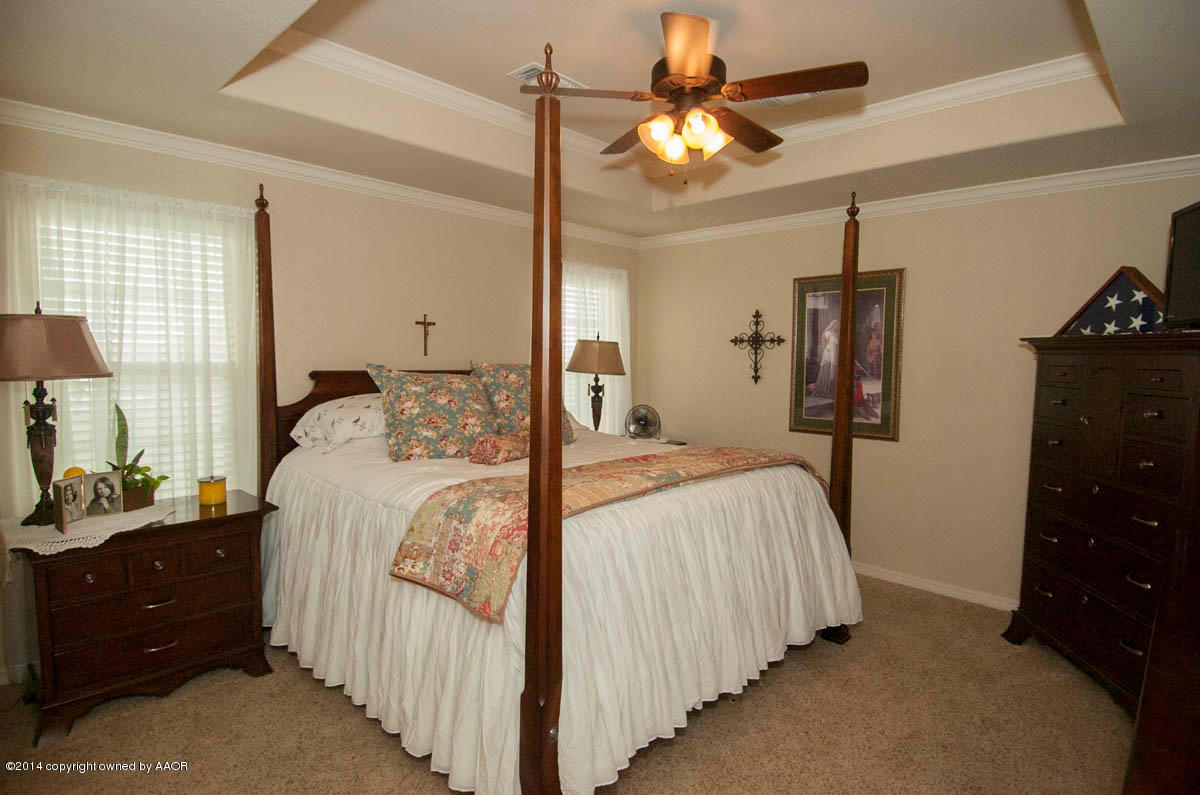 18301 Copper Ridge Bushland, TX 79124 - Photo 13 of 38 a bedroom with a bed a chandelier and a flat tv screen on dresser