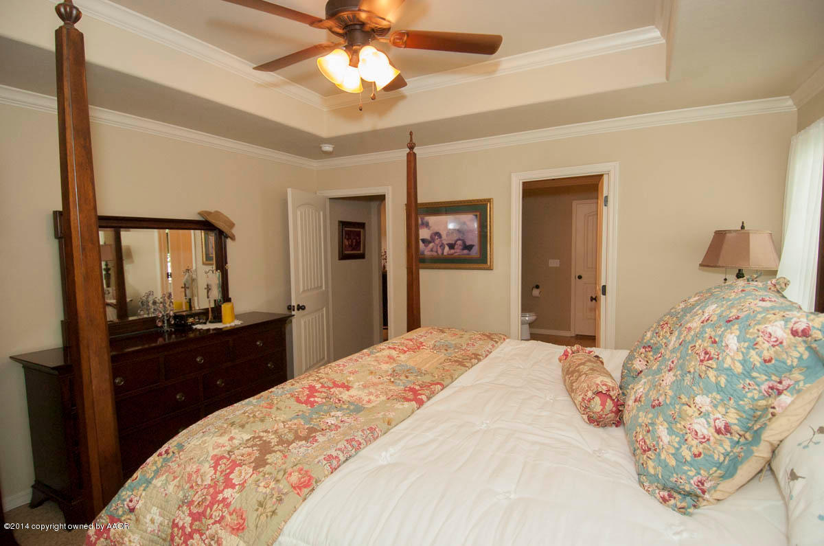 18301 Copper Ridge Bushland, TX 79124 - Photo 14 of 38 a bedroom with a bed and a chandelier