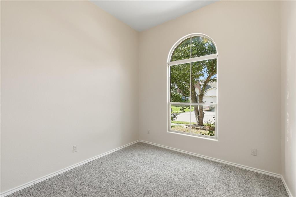 720 Rio Bravo Drive Fort Worth, TX 76052 - Photo 15 of 38 Arched window providing ample natural illumination, neutral wall tones, white trim, and a grey carpeted floor