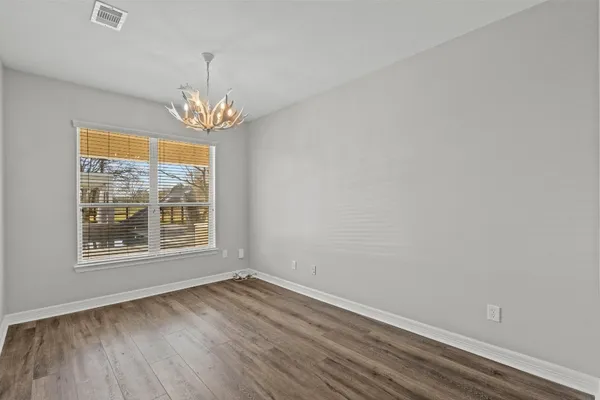 a view of a hallway with a chandelier fan and windows