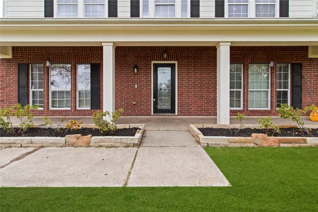 a front view of a brick house with a yard