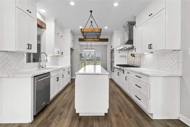 a kitchen with granite countertop a sink cabinets stainless steel appliances and a counter top space