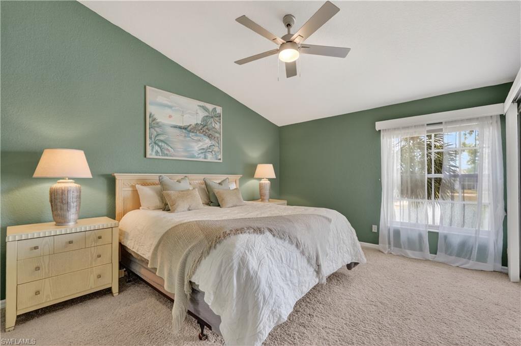 13061 Hamilton Harbour Drive, Unit R5 Naples, FL 34110 - Photo 18 of 39 a bedroom with a large bed and a chandelier fan