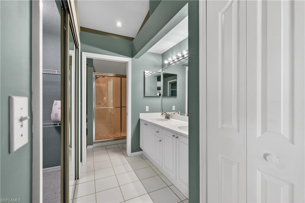 13061 Hamilton Harbour Drive, Unit R5 Naples, FL 34110 - Photo 21 of 39 a bathroom with a double vanity sink and mirror