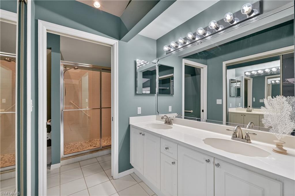 13061 Hamilton Harbour Drive, Unit R5 Naples, FL 34110 - Photo 24 of 39 a spacious bathroom with a double vanity sink a mirror and a shower