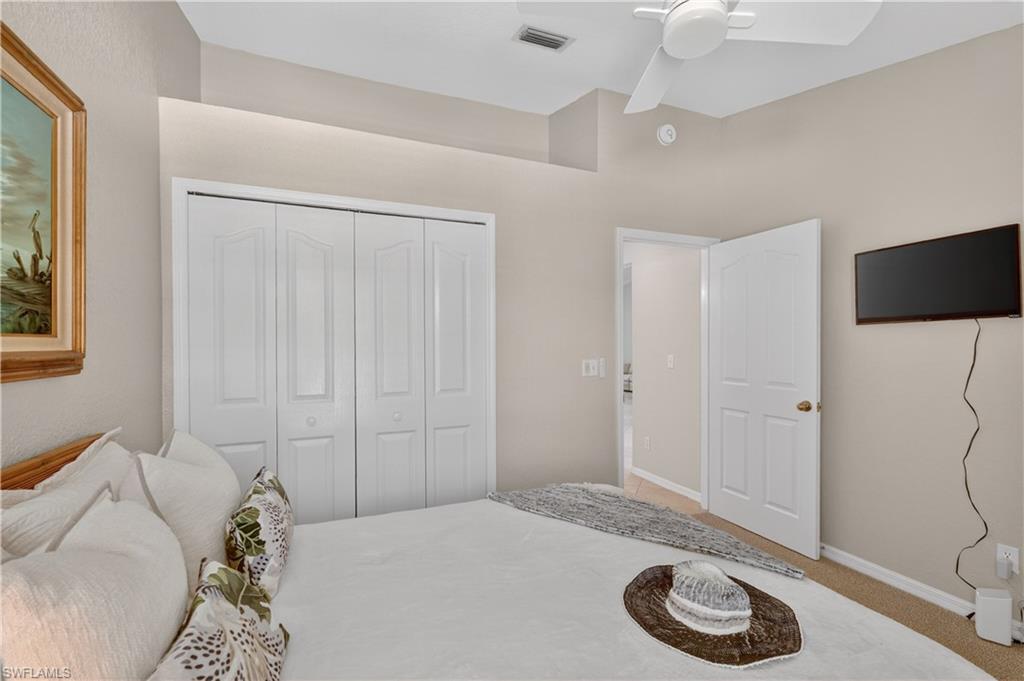 13061 Hamilton Harbour Drive, Unit R5 Naples, FL 34110 - Photo 28 of 39 a bedroom with a bed and a flat screen tv
