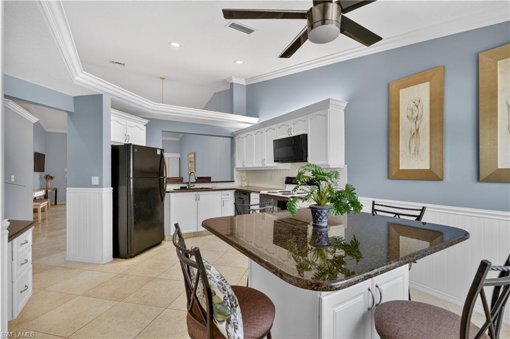 13061 Hamilton Harbour Drive, Unit R5 Naples, FL 34110 - Photo 8 of 39 a kitchen with stainless steel appliances granite countertop a dining table chairs a sink and dishwasher a refrigerator with wooden floor