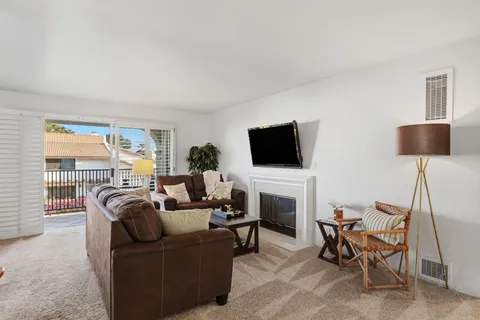 a living room with furniture a flat screen tv and a fireplace
