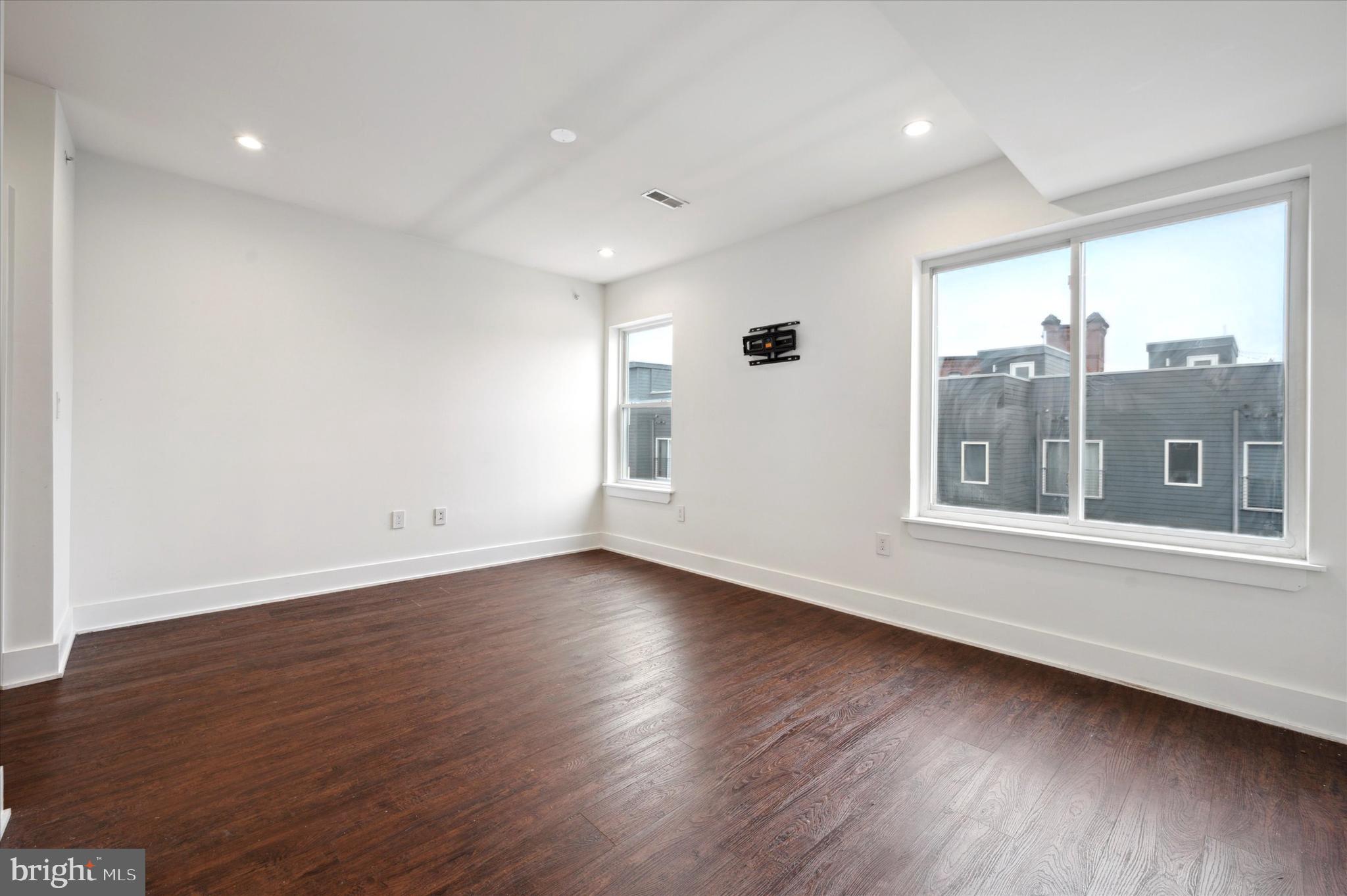 1219 North 5th Street, Unit 2 Philadelphia, PA 19122 - Photo 13 of 16 an empty room with wooden floor and windows