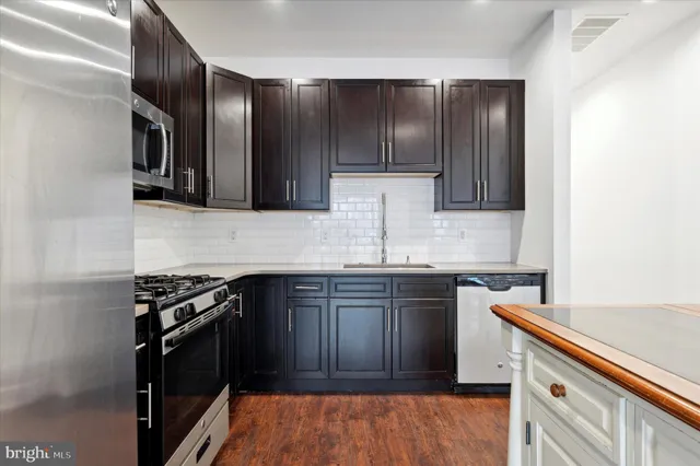 a kitchen with granite countertop stainless steel appliances and wooden cabinets