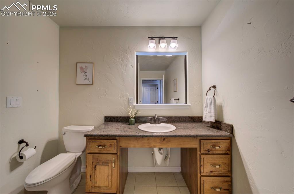 1905 Mesa Road Colorado Springs, CO 80904 - Photo 32 of 44 a bathroom with a granite countertop sink a toilet and mirror