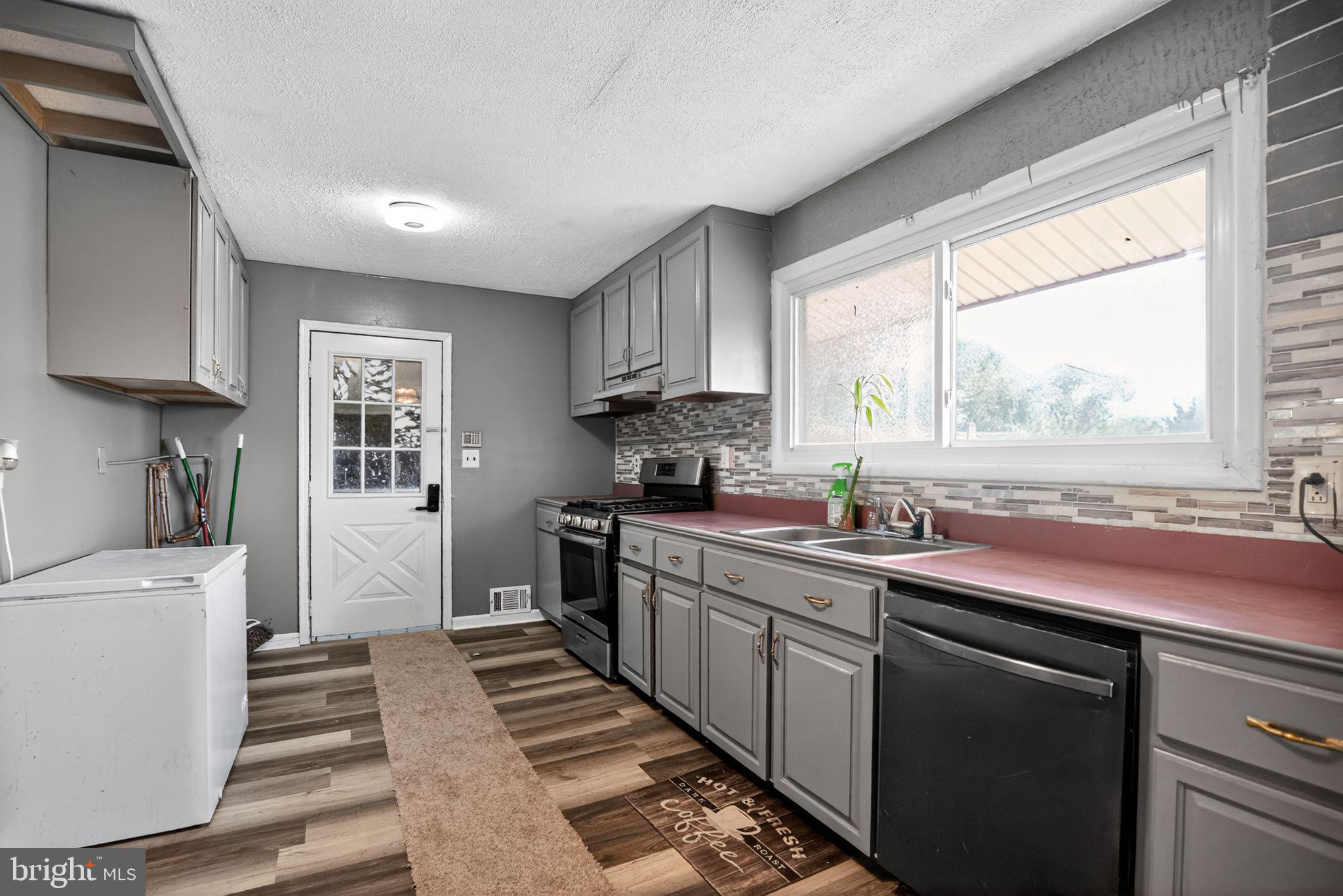 11 La Gorce Boulevard Burlington, NJ 08016 - Photo 12 of 22 a kitchen with stainless steel appliances a sink stove and a window