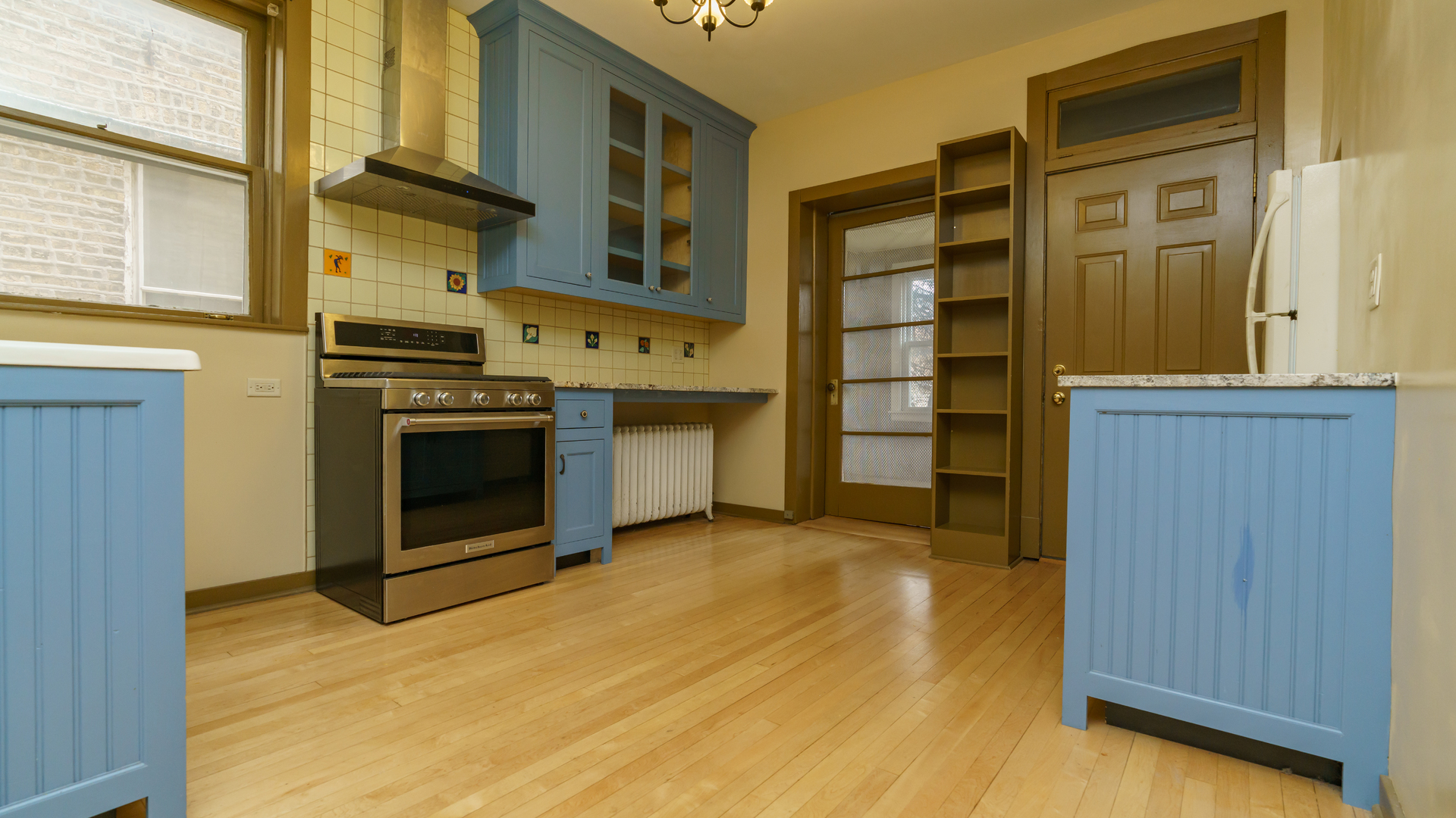 2644 North Harding Avenue Chicago, IL 60647 - Photo 6 of 37 a view of a kitchen with stainless steel appliances wooden floor and staircase