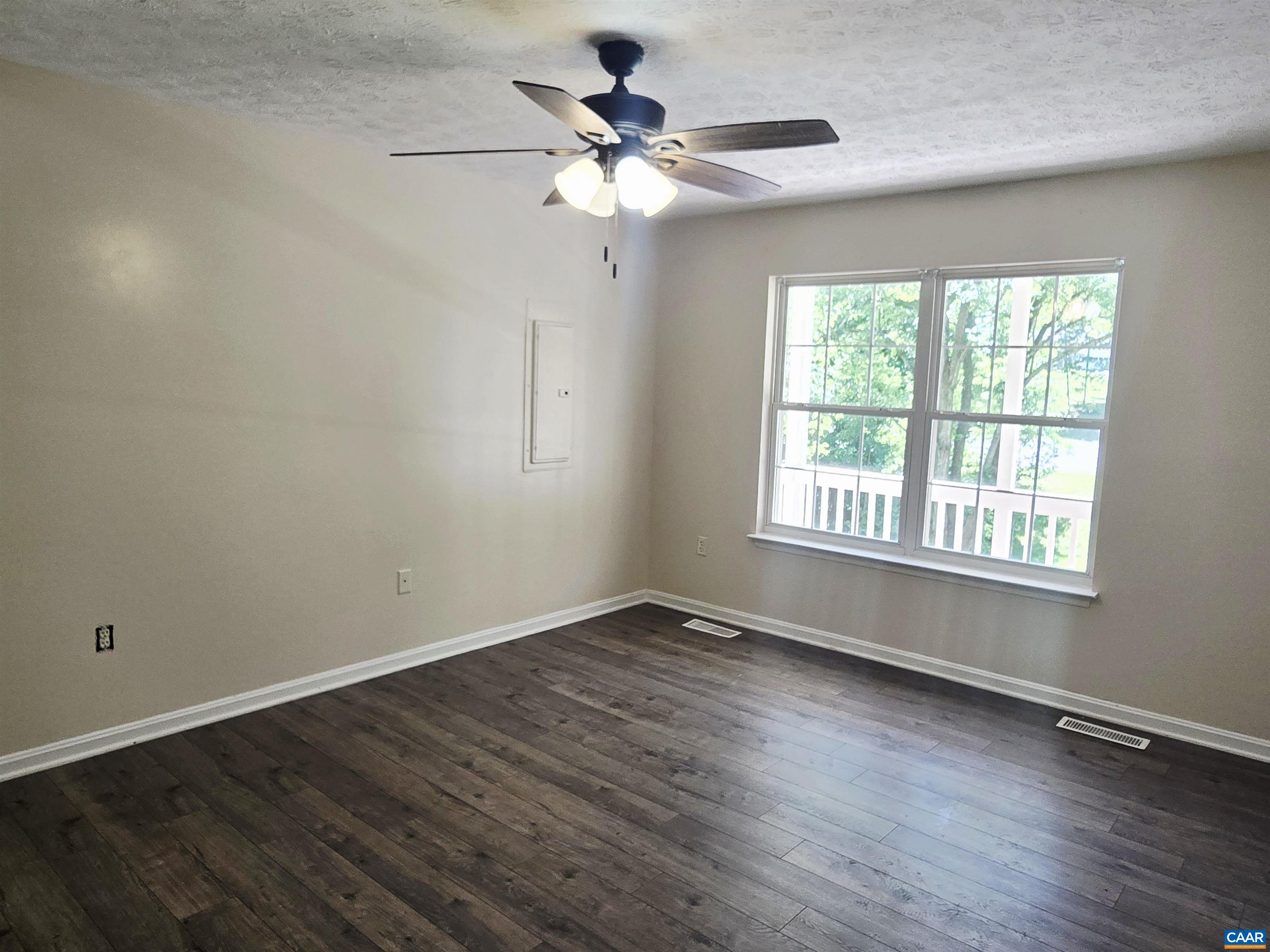 79 Haney Road Ruckersville, VA 22968 - Photo 10 of 15 an empty room with wooden floor chandelier fan and windows