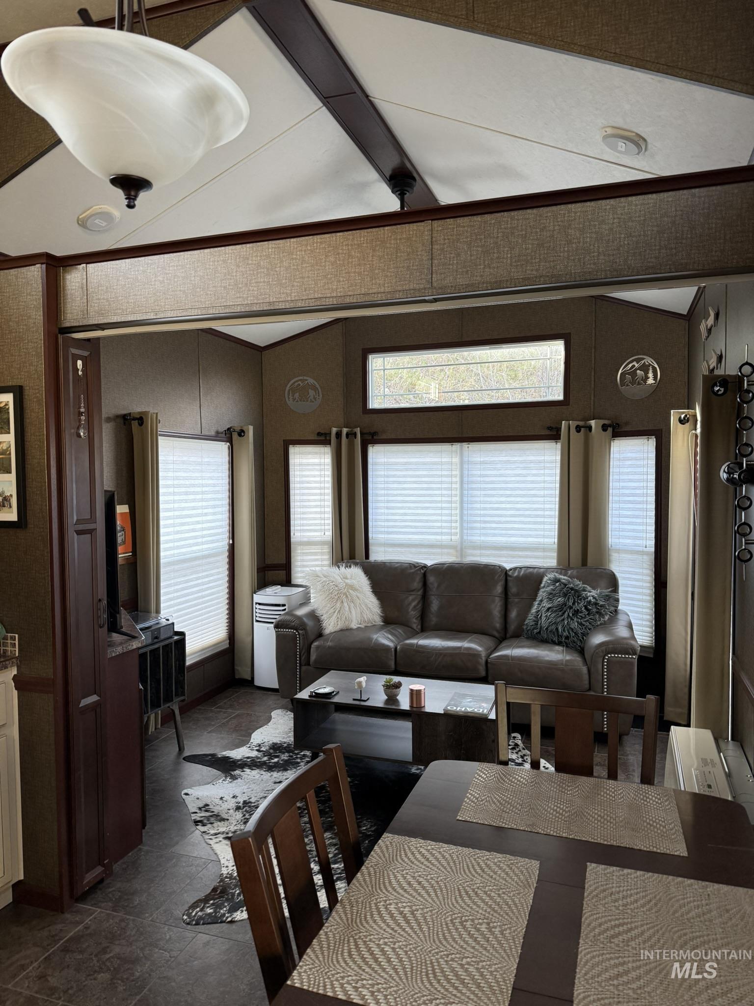 532 Old Pollock Road Riggins, ID 83549 - Photo 11 of 25 Living room featuring vaulted ceiling with beams, crown molding, and dark stone finish floors