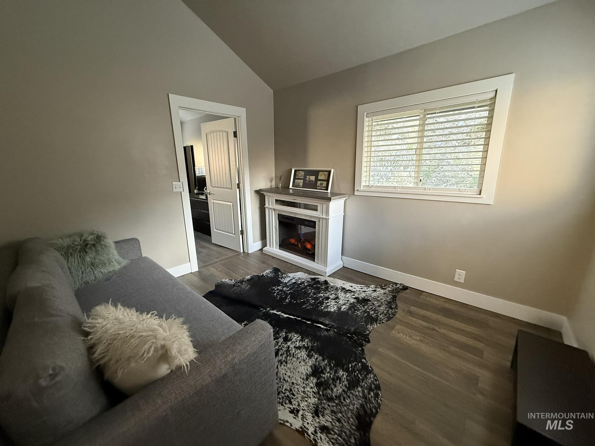 532 Old Pollock Road Riggins, ID 83549 - Photo 21 of 25 Living area featuring dark wood-type flooring, vaulted ceiling, and a glass covered fireplace